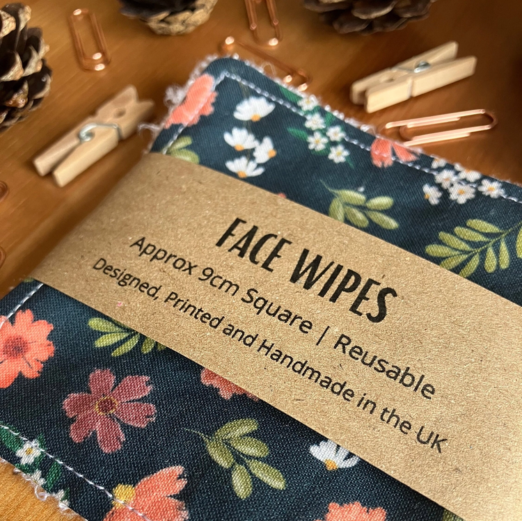 A pack of four reusable face wipes with a floral pattern. 