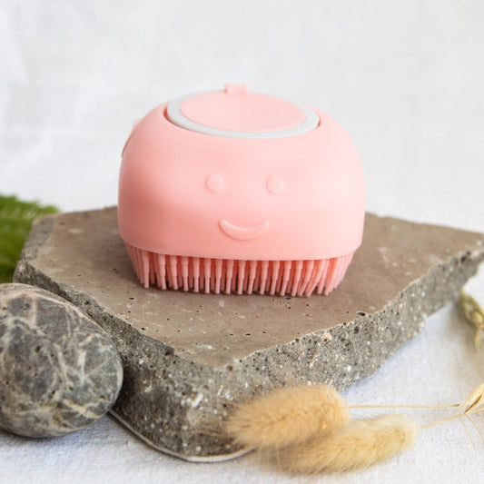 Pink silicone scrubber on a stone surface with a white background