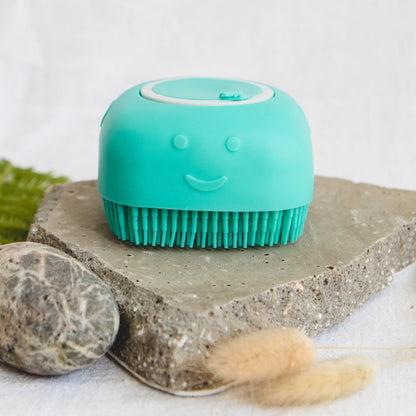Turquoise dog shampoo cleaning brush with a smiley face on a stone surface
