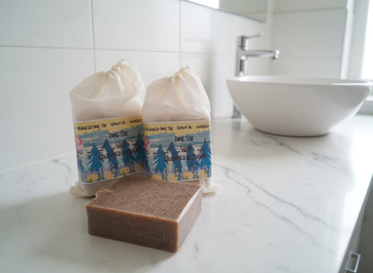 Two bags of pine tar soap with a bar of soap in front on a wooden surface.